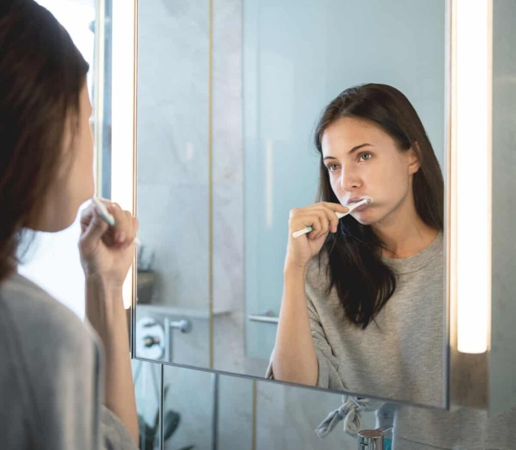 Woman brushing her teeth - weird pregnancy symptoms